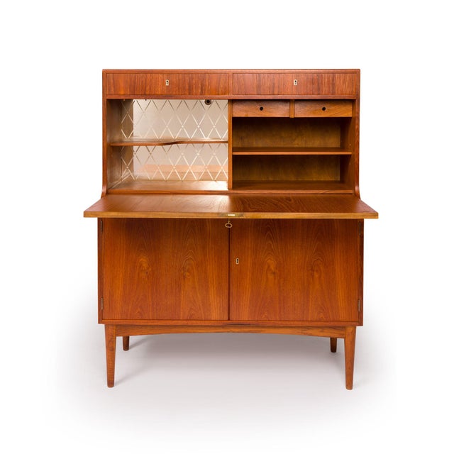 A beautiful example of Danish Mid-Century Modern craftsmanship, this vintage teak bar/hutch features richly figured teak...