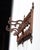 Antique oak and cast iron hanging coat/hat rack with four sliding hooks and three ornately decorated brackets with...