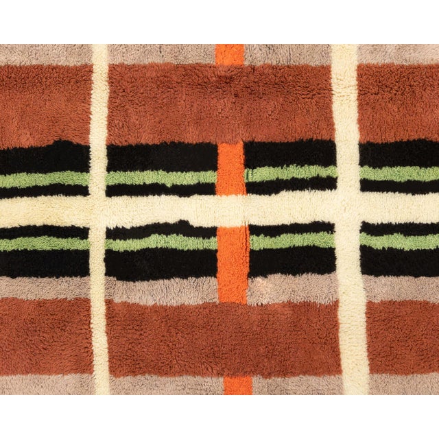A patchwork of sun-warmed color, woven into quiet geometry. This hand-knotted wool rug unfolds in a mosaic of bold color-...