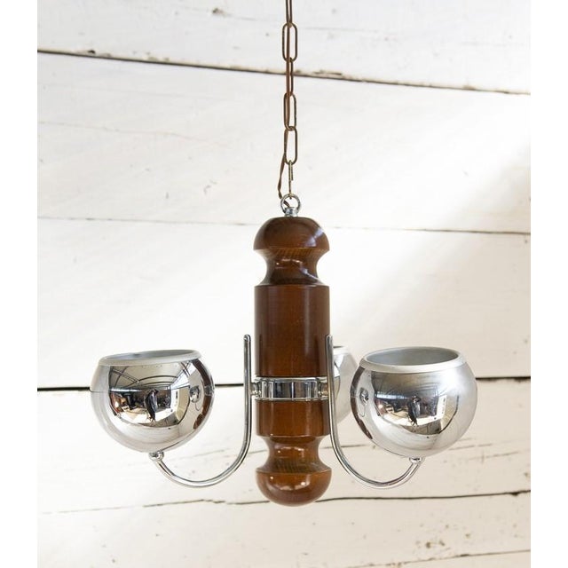 Iconic wood and chrome-plated metal chandelier, featuring the typical Space Age spheres of the late 1960s. The main wooden...