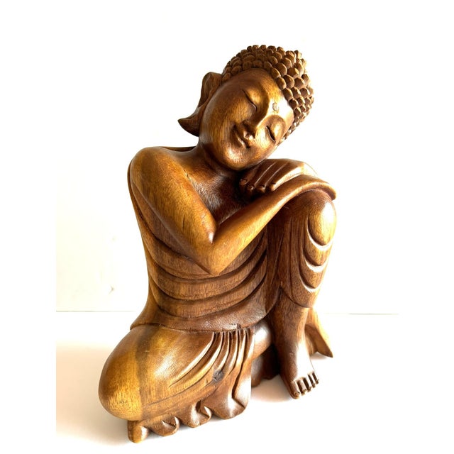 This is a hand-carved wooden "resting Buddha" or "Dreaming Buddha" sculpture in a peaceful, contemplative pose with head...