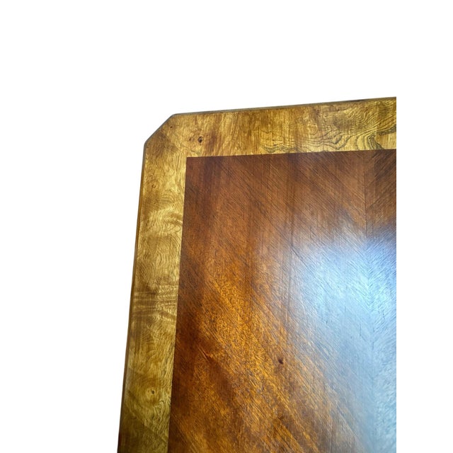 A beautifully refinished English Country writing desk showcasing an elegant combination of rich natural wood tones and a...