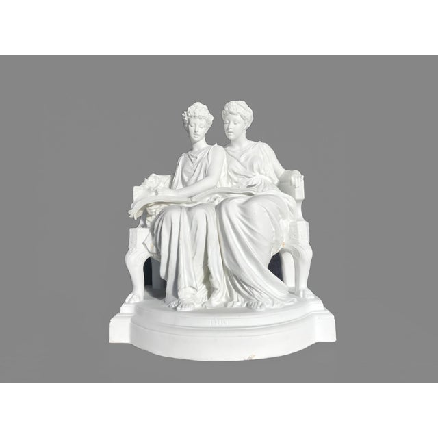 An antique sculpture titled "Duo" This parian porcelain sculpture depicting two young women in flowing dresses seated on a...