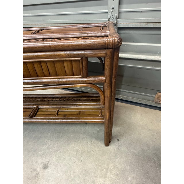 A beautiful palm beach style two-tiered bamboo console with split bamboo detailing and intricate woven rising sun...