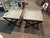 A stylish pair of vintage wood and iron side tables featuring warm natural wood tops set on sleek black metal folding-...