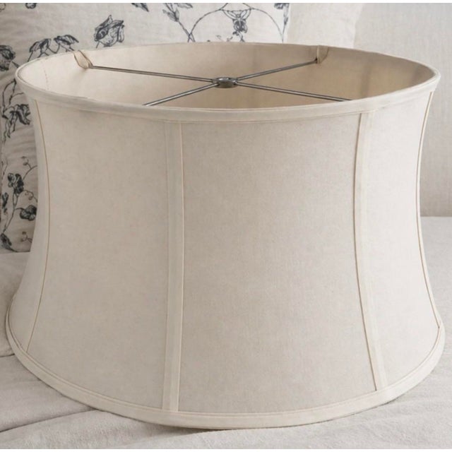 A large-scale neutral fabric lamp shade featuring a softly curved silhouette and tailored mid-century construction....