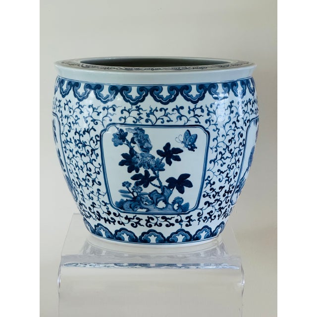 A porcelain jardiniere with underglaze blue decoration. The design is set in four reserves alternating with birds and...