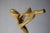 Abstract brass musician sculpture from the 1980s, with an elongated curved figure holding an outstretched instrument, on a...