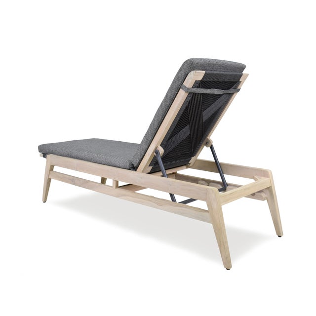 A sleek adjustable chaise lounge chair adapted from a Hans Wegner original featuring a teak and woven rope frame...