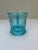 Single vintage pressed turquoise colored glass cup with handle. Features butterfly decoration.