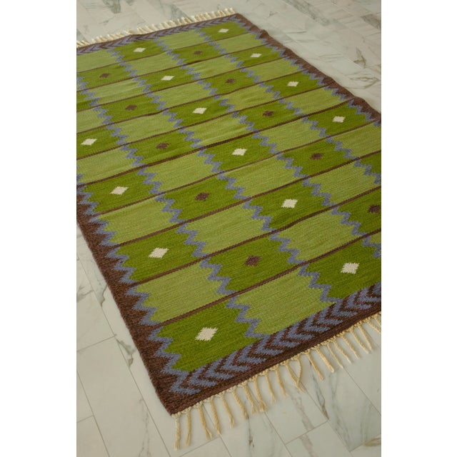 A beautiful green, purple and brown shaded rug in a design called "Garden" by Berit Koenig Woelfer for Swedish Rug...