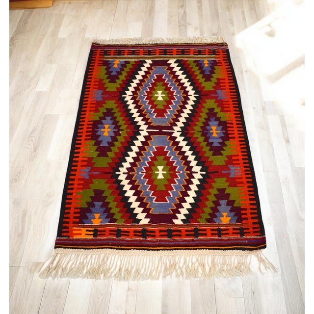 Offred a vintage Turkish Antalya Barak patterned Kilim rug made from wool on wool and natural dyes. The rug is in...