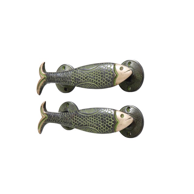 A pair of fish shaped door handles or cabinet pulls made of brass with a green finish. Cast with delicate scales and...
