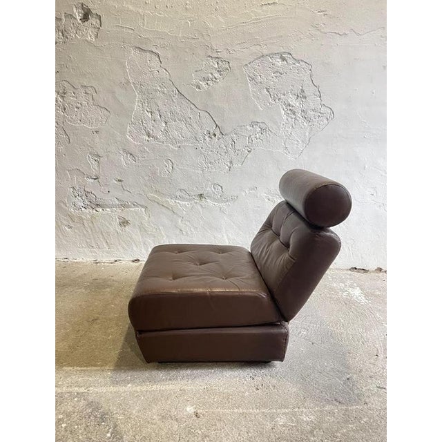 This vintage leather chair bed reflects the practical and playful design approach of the 1970s, where comfort and...