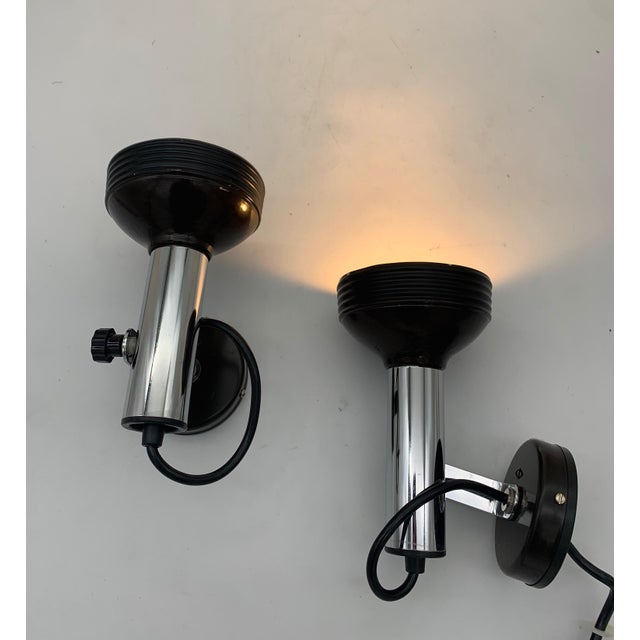 This pair of wall lamps, attributed to Stilnovo, is adjustable. Typical 1970s spotlights. The material is sheet metal,...