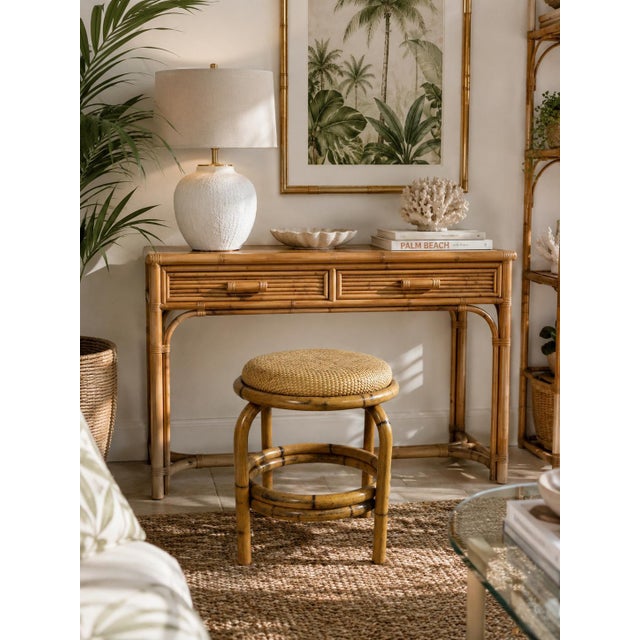 Charming vintage round ottoman featuring a natural bamboo frame with curved legs and a double-ring stretcher base. The...