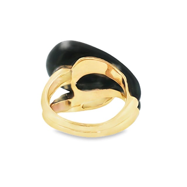 A contemporary late 20th-century offset knot ring featuring a black onyx inlay. Crafted in 14k yellow gold. The ring...