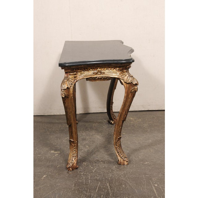 An Italian Rococo style, serpentine console table, with marble top, from the 19th century. This antique table from Italy...