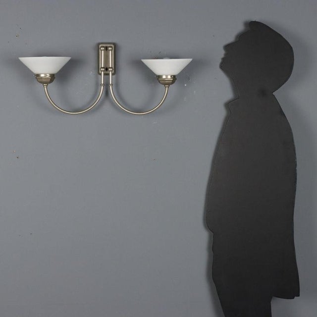 Vintage wall lamp with a metal frame and two light sources with glass diffusers. It features two E14 sockets. This piece...