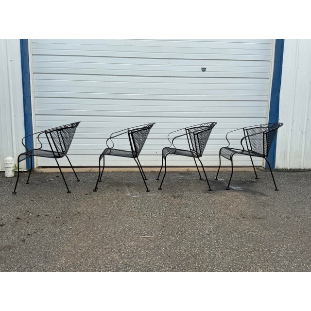 Offered is a Set of 4 Vintage Woodard Style Outdoor Wrought Iron Arm Chairs. These classic patio chairs feature black...