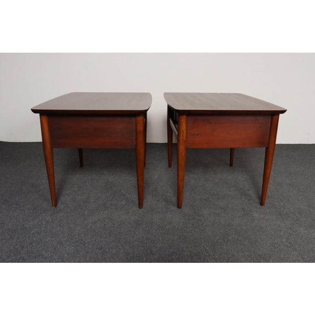 Pair of vintage nightstands/end tables by Lane (ca. 1960s, USA). Composed of a walnut frame with sculptural tapered legs...