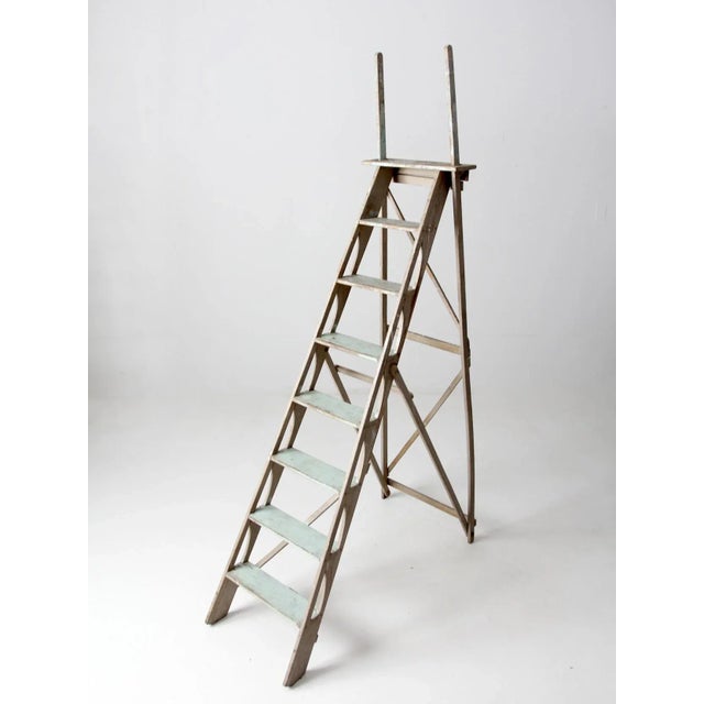 This is a antique wooden ladder. The old ladder features wood framing and supports with windows on the side rails. The...