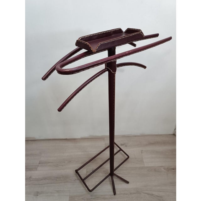 Iconic, chic, and luxurious valet stand by Jacques Adnet. France, 1950s. Tubular metal frame, entirely covered in saddle-...