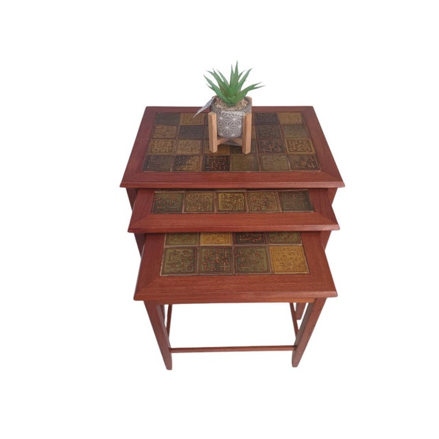 Elevate your living space with this exquisite trio of vintage danish design nesting tables, crafted in the 1970s....