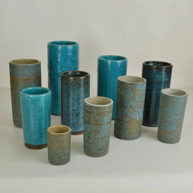 Set of ten studio ceramic cylinder vase of various heights in turquoise tones created by in 3 different glazes. They are...