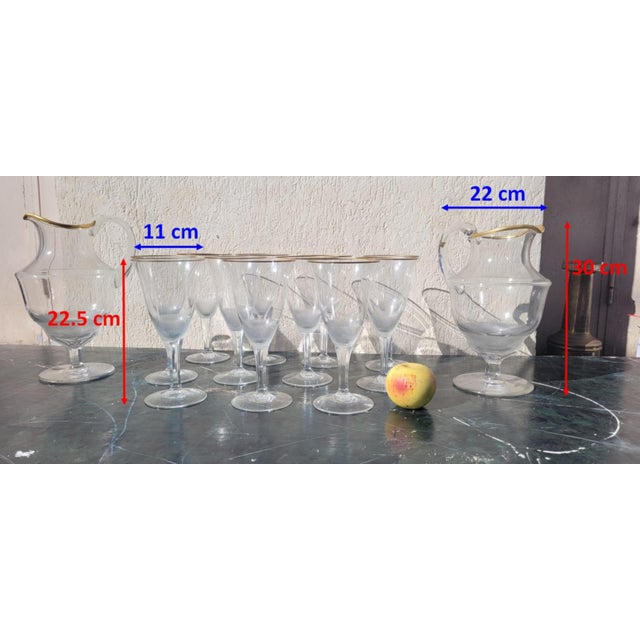 An elegant service comprising 11 large stemmed glasses and 2 carafes: exquisite glasswork, with the base of the body cut...