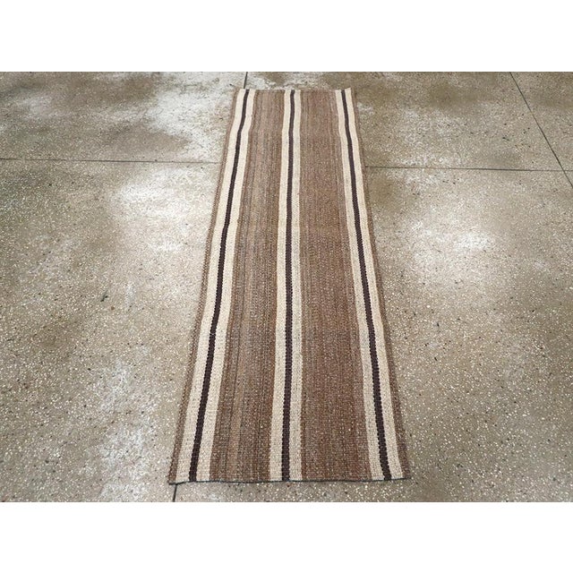 This mid-20th century Turkish flatweave kilim runner, measuring 2' 0" x 6' 3", exemplifies the enduring beauty of...