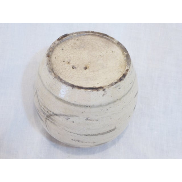 This antique rustic Chinese storage vessel is hand thrown and has a simple brushed design.