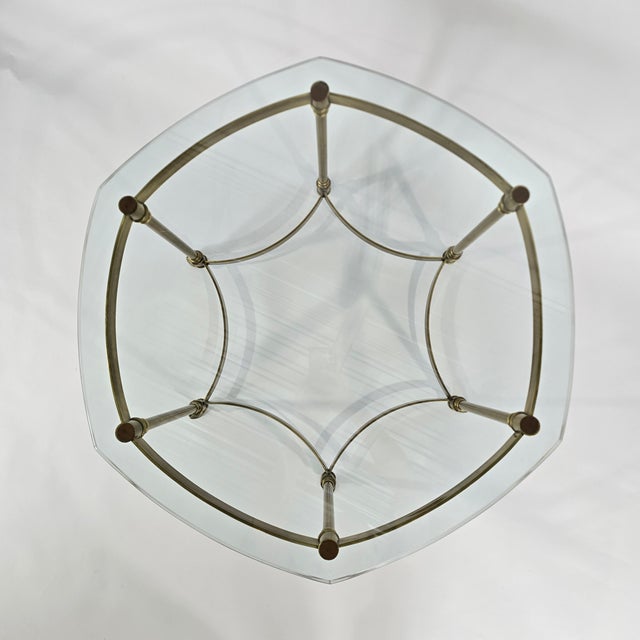 Vintage Regency style brass side table with a hexagonal 5/8" thick, beveled glass top. The table has 6 legs, hooved feet,...