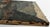 This atmospheric early modernist landscape painting depicts a picturesque European village nestled within a dramatic...