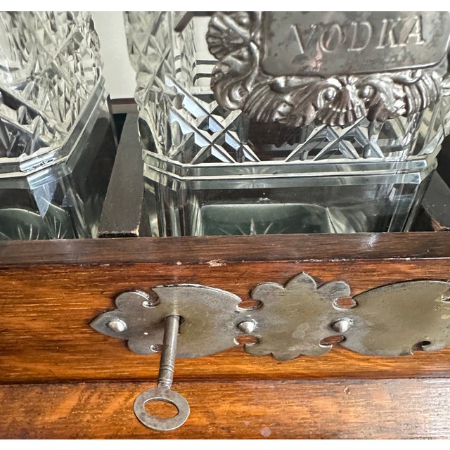 Vintage crystal tantalus bar set with working lock & key. Elegant three-decanter set in original wood case with silver-...