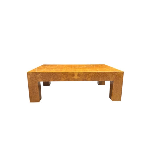 Elegant rectangular coffee table made of burl veneer, with a glossy finish that highlights the natural grain of the wood....