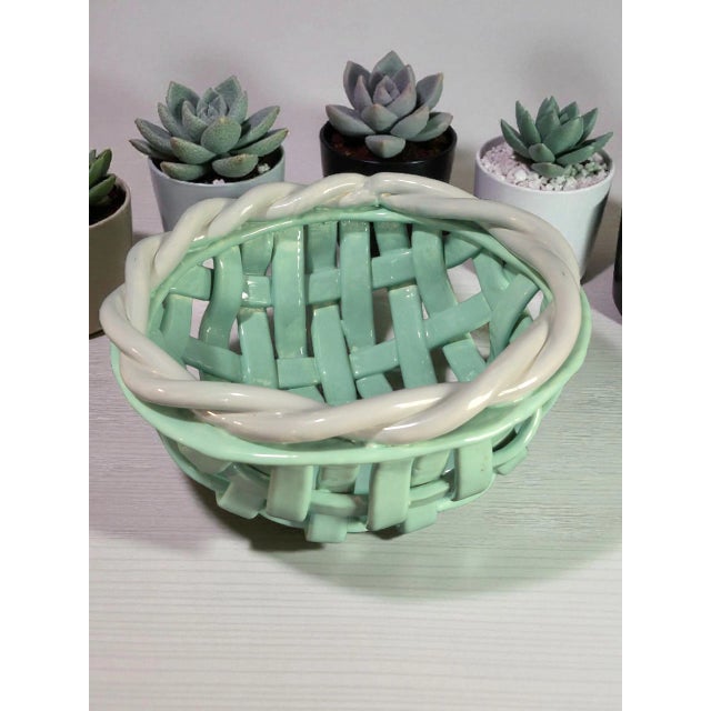 The Italian Glazed Ceramic Open Weave Teal & White Basket by M&M is a contemporary decorative piece featuring a trellis...