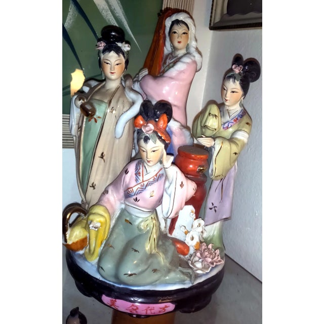 Japanese Geisha musicians pose together on a round shaped platform. The elegant decorative figures feature highly detailed...