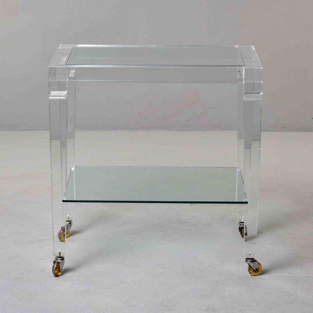 This Italian two-tier table is constructed in clear Lucite, raised on four square-section legs that taper toward the foot....