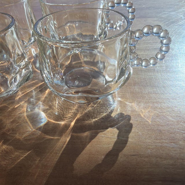 This set of 4 vintage Hazel-Atlas snack cup punch cups features a bubble/beaded handle design in clear glass. Made in the...