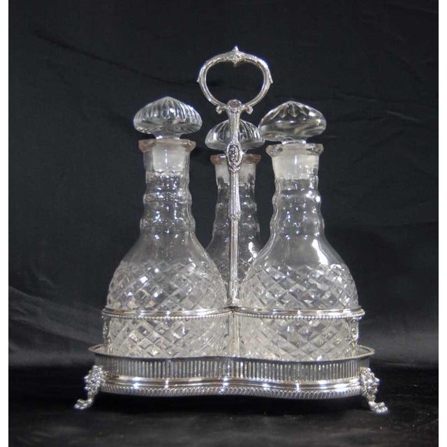 Gorgeous Vanberg silverplate three decanter bottle set. The bottles have been intricately crafted from cut glass with...