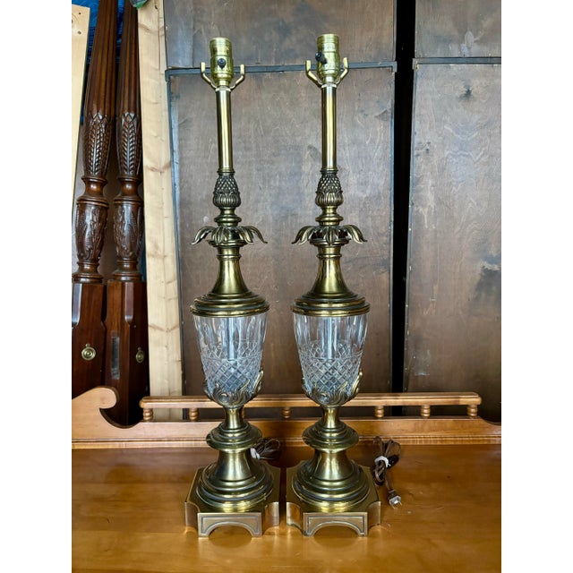 Striking pair of vintage Stiffel table lamps featuring substantial brass construction with beautifully cut crystal bodies...