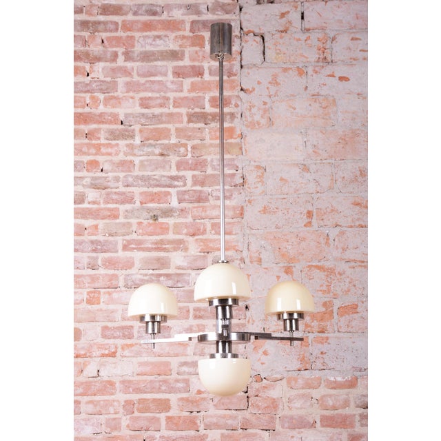 This chandelier is a prime example of Czechoslovak design from the 1930s, masterfully blending the decorative elements of...