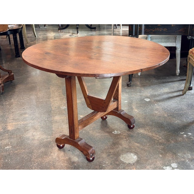 19th century French oak wine table with a round plank top that tilts upright to store flat against a wall. The top has...