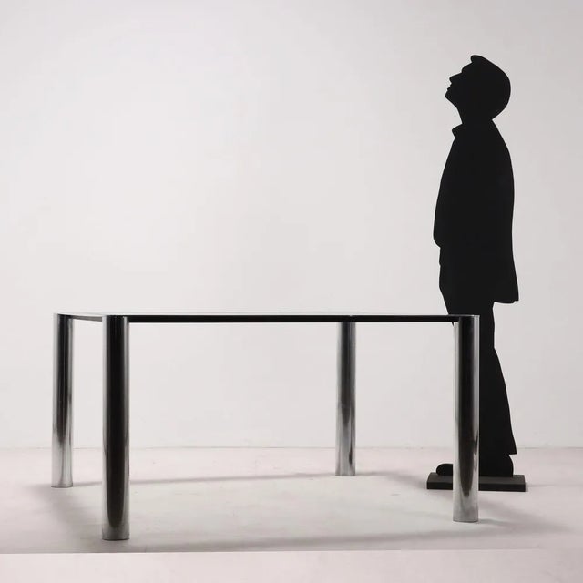Table with chromed metal and glass structure. Good condition, has a dull stain on the structure. This piece is attributed...
