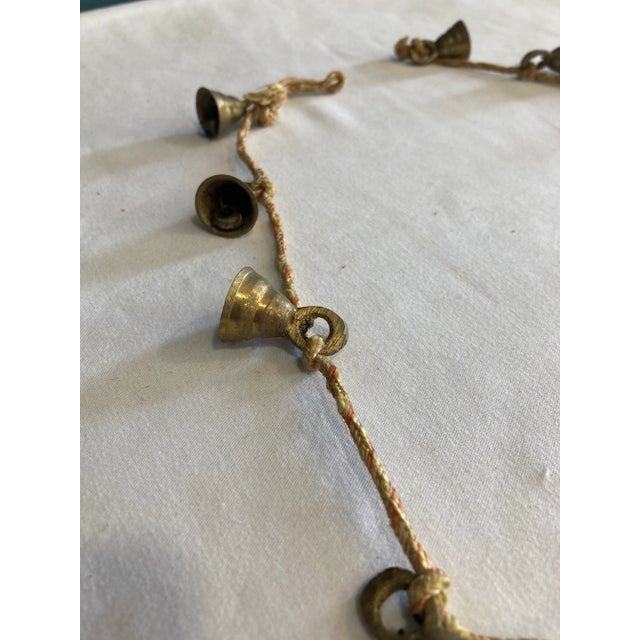 This vintage handcrafted brass bell garland features aged brass bells strung on a braided rope, creating a charming...