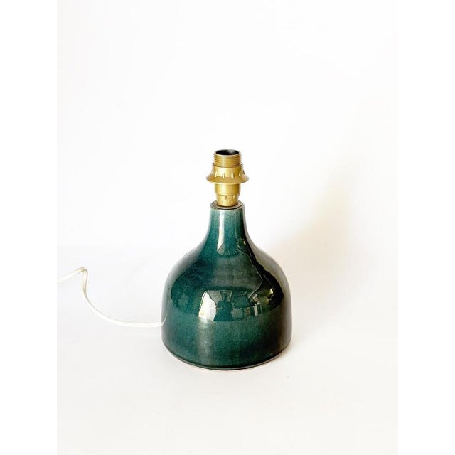 The lampshade is not included. Elegant French table lamp featuring a bottle-shaped ceramic base finished in a rich deep...