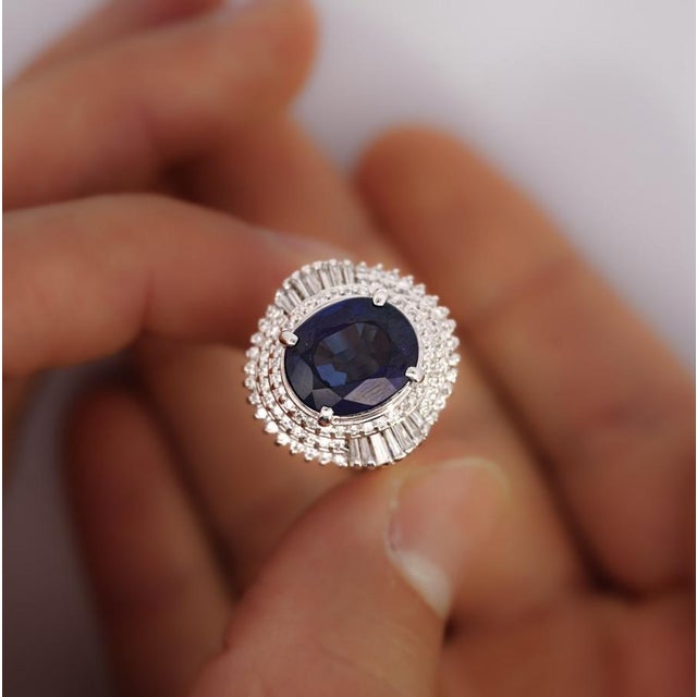 GIA certified 6.75 carat oval cut natural blue sapphire with a a baguette cut diamond halo in a ballerina style platinum...