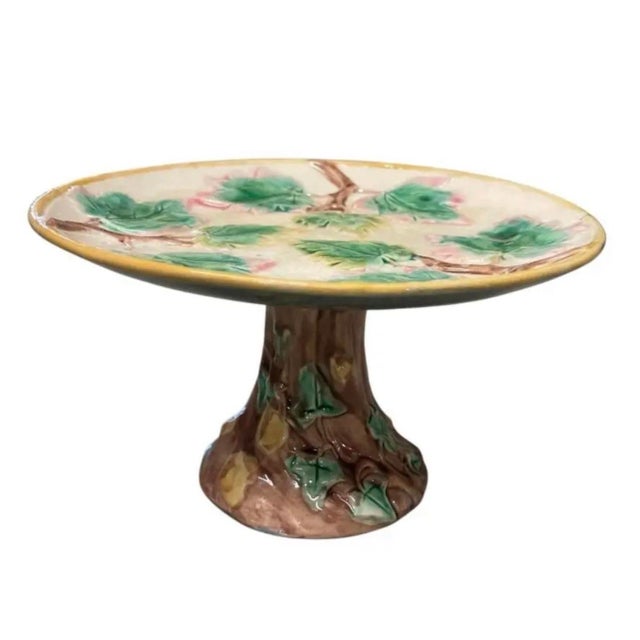 Bring a touch of classic botanical charm to your space with this vintage majolica pedestal dish. Crafted with dimensional...