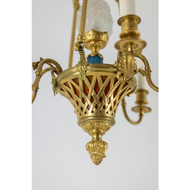 Louis XVI style chandelier in gilded bronze and orange and blue glass paste. French work realized circa 1900. This piece...